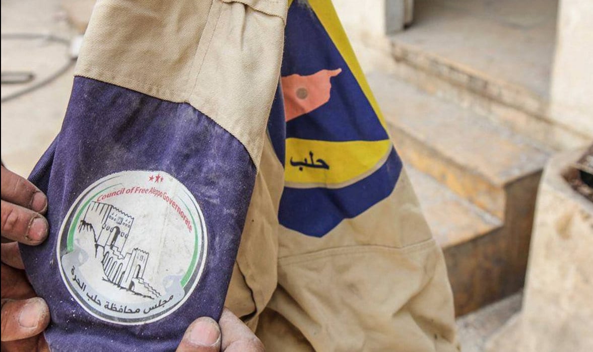 Al Nusra Front, Al Qaida i Syria logo på White Helmets uniform.